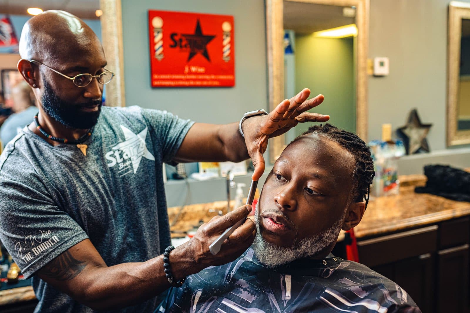 J. Wise shaping a client's beard at Starz