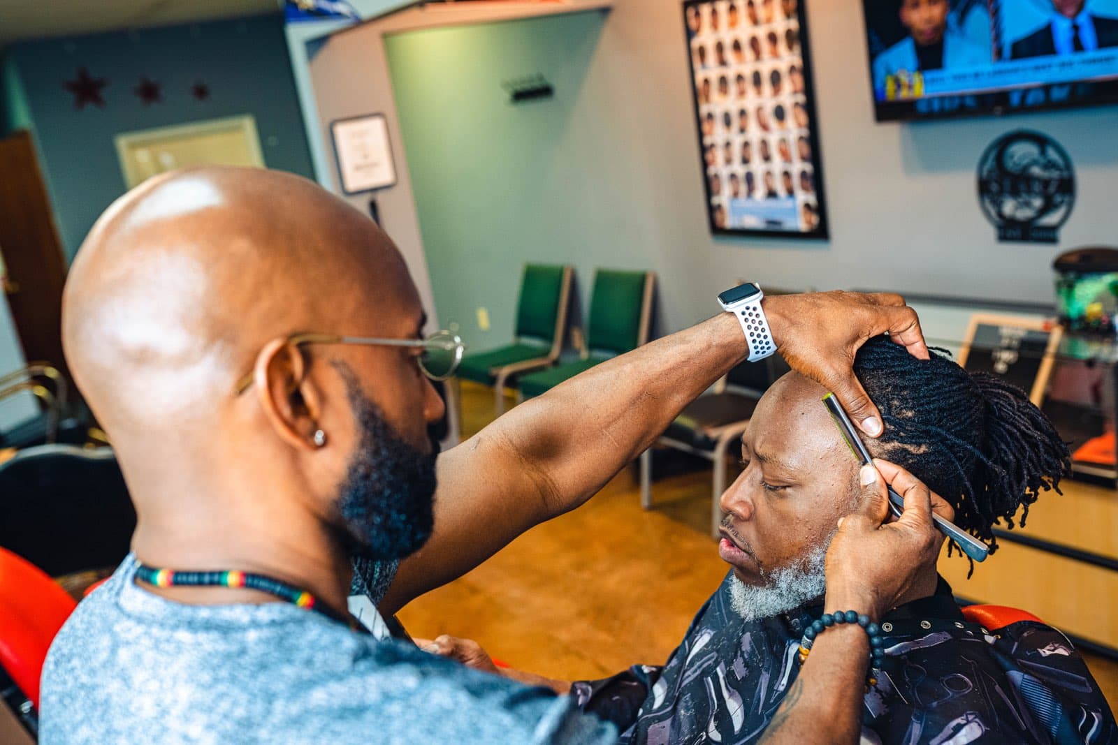 J. Wise finishing a client's hairline with a razor